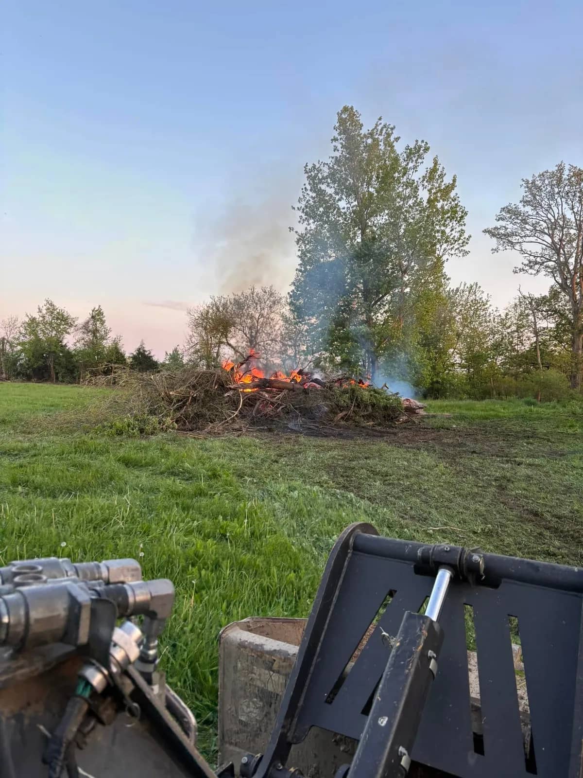 Brush pile burning at dusk after a clearing job