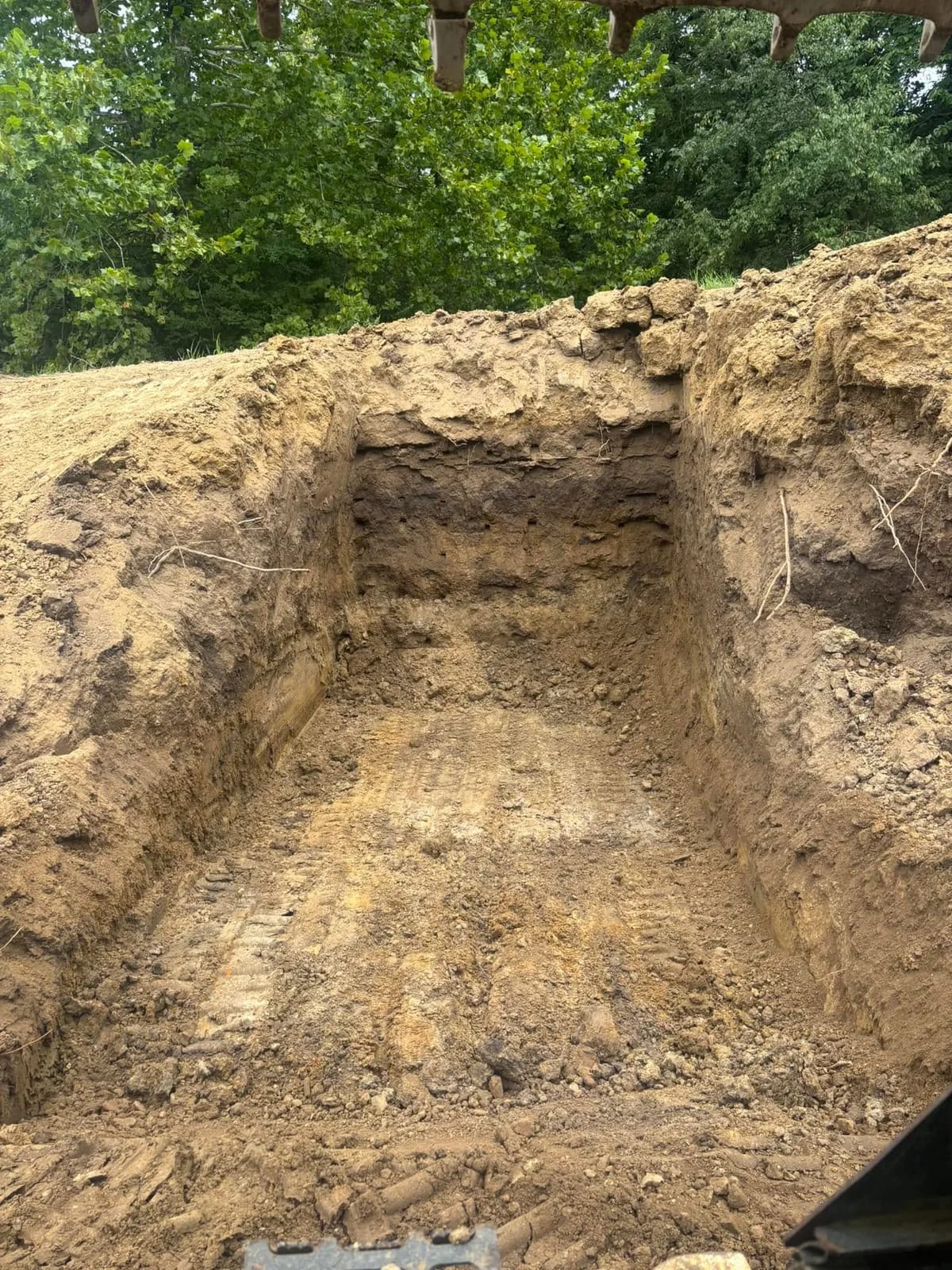 Excavated pit with straight, vertical walls cut to depth